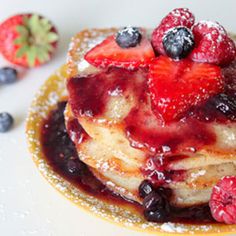 pancakes with berries and powdered sugar on top