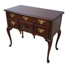 a wooden desk with two drawers on one side and gold decorations on the other end