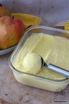 a bowl of pudding with a spoon in it next to some bananas and pears