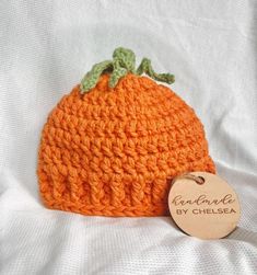 an orange crocheted hat with a tag on it