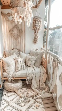 a living room filled with lots of pillows and blankets on top of a wooden floor