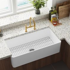 a white kitchen sink sitting on top of a counter