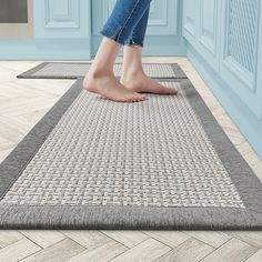 a woman standing on top of a gray rug