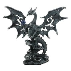 a statue of a dragon sitting on top of a rock with its wings spread out