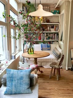 a living room filled with lots of furniture and a table in front of a window