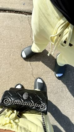 a handbag sitting on the ground next to someone's feet