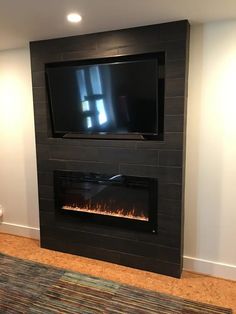 a flat screen tv mounted on the wall above a fireplace