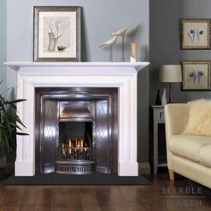 a living room with a fire place next to a couch and two pictures on the wall