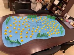 a woman taking a photo of a cake with yellow ducks on it that says are you happy today?