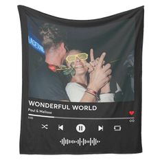 a man and woman kissing in front of a black wall hanging tapestry with the words wonderful world on it