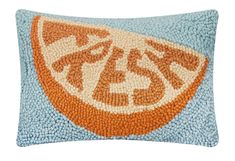 an orange slice on blue and white pillow with the word's logo in it