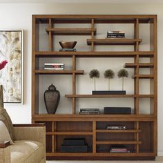 a living room filled with furniture and a large book case on top of a wooden shelf