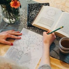 a person sitting at a table with an open book and coffee cup in front of them