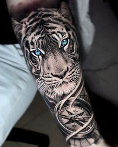 a man's arm with a tiger and clock tattoo on it