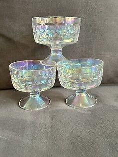 three glass goblets sitting on top of a couch