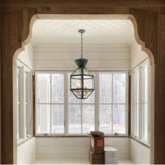 an empty room with a lantern hanging from the ceiling