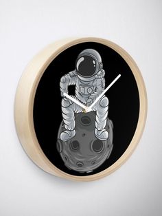 an astronaut is sitting on the moon wall clock