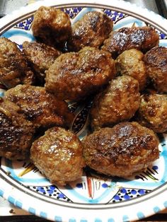 some meatballs are on a blue and white plate