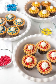 some cupcakes are sitting on plates with candy in them