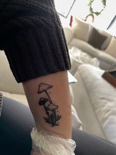 a person with a mushroom tattoo on their arm and leg is holding a plastic bag