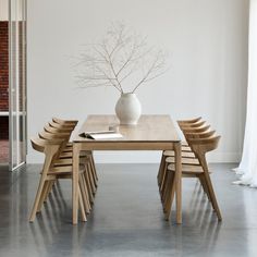 a table with chairs and a vase on it