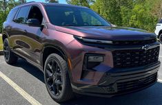 the front end of a purple chevrolet suv parked in a parking lot next to trees