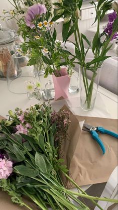 flowers in vases sitting on a table with scissors