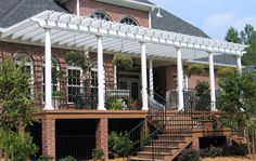 a large brick house with white columns and railings