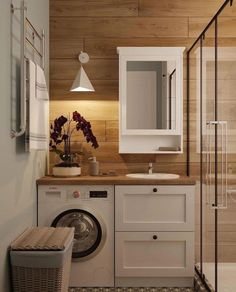 a washer and dryer in a bathroom with wood paneling on the walls