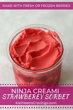 a small glass jar filled with strawberry ice cream on top of a white tablecloth