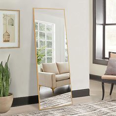 a large mirror sitting in the middle of a living room next to a couch and chair