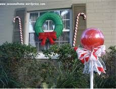 a christmas wreath and candy canes are in front of a house