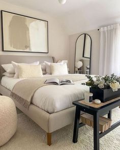 a bedroom with a bed, mirror and table in it