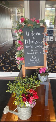 a welcome sign and potted flowers on a table