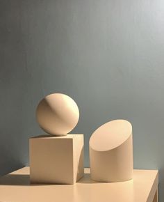 two white sculptures sitting on top of a table