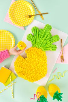 a pineapple shaped cake sitting on top of a white plate next to yellow and green decorations