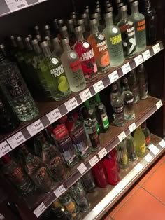 bottles of alcohol are on shelves in a liquor store, with price tags below them