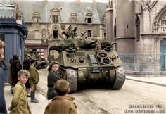 a group of people standing around a tank