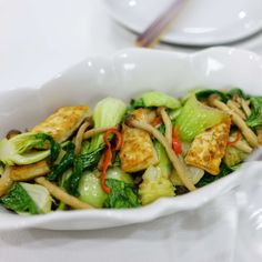 a white bowl filled with stir fry vegetables