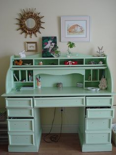 a green desk with lots of drawers underneath it