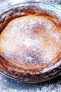 a cake sitting on top of a glass plate covered in powdered sugar