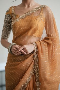 A photo of a Pakistani bride wearing a stunning red saree with subtle lacework and delicate embroidery along the pallu. The blouse has a modest square neckline and long sleeves. The bride has soft waves in her hair and is wearing minimal jewelry. Burnt Orange Saree, Long Sleeve Saree, Convo Ideas, Long Blouse Saree, Long Sleeve Saree Blouse, Saree Photography, Desi Attire, Bridal Anklet, Girly Style Outfits