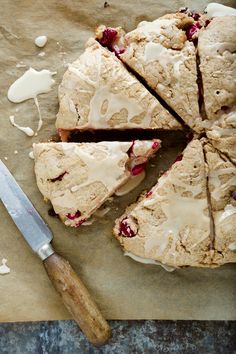 a cake with white icing on it next to a knife