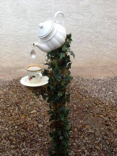 a white tea pot and cup on top of a tree