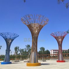 three metal sculptures in the shape of trees