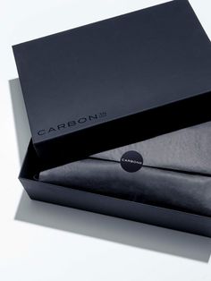 two black boxes sitting next to each other on top of a white surface with the word carbon printed on it