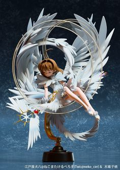 an anime figurine sitting on top of a circular object with white wings and red eyes