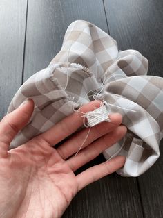 a hand holding a piece of cloth on top of a wooden floor