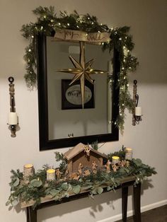 a christmas mantle decorated with greenery and candles