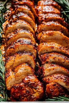 sliced pork roast on a platter with rosemary sprigs